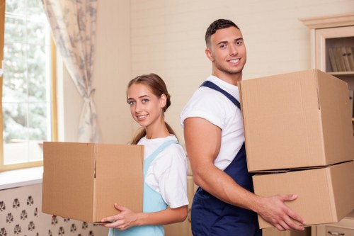 Removalists carrying boxes and furniture at a Brentpark property