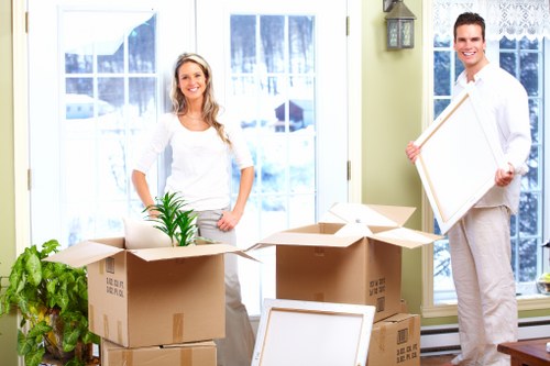 A moving team handling furniture and boxes on a Brentpark street