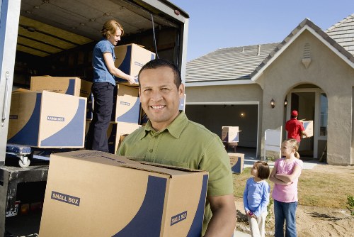 Movers transporting office items through a commercial building